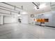 Spacious garage with epoxy flooring, overhead lighting, and storage cabinets at 2333 N 87Th Pl, Mesa, AZ 85207