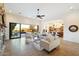 Open living room featuring sliding glass doors to the pool, comfortable seating, and an open-concept kitchen at 2333 N 87Th Pl, Mesa, AZ 85207