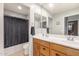 A bathroom with a double sink vanity and a shower with a black curtain at 24805 W Vista Norte St, Buckeye, AZ 85326