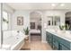 Bathroom showing a tub, vanity with double sinks, and an open view to the main bedroom at 24805 W Vista Norte St, Buckeye, AZ 85326