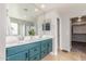Bathroom featuring double sink vanity with blue cabinets, a large mirror, and tile flooring at 24805 W Vista Norte St, Buckeye, AZ 85326