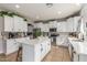 Bright kitchen with white cabinets, stainless steel appliances, an island, and stone countertops at 24805 W Vista Norte St, Buckeye, AZ 85326