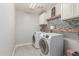 A laundry room with side-by-side appliances and overhead shelving at 24805 W Vista Norte St, Buckeye, AZ 85326