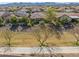 Expansive grassy common area behind home with mature trees and landscaping, plus a view of the home's rear windows at 26336 W Tina Ln, Buckeye, AZ 85396