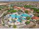 Aerial view of a resort-style community pool with palm trees, lounge chairs, and multiple swimming areas at 26336 W Tina Ln, Buckeye, AZ 85396