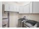 Efficient laundry room with modern washer and dryer units and ample white cabinetry for storage and organization at 26336 W Tina Ln, Buckeye, AZ 85396