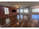 Spacious living room featuring hardwood floors, a ceiling fan, and large windows letting in ample natural light at 26336 W Tina Ln, Buckeye, AZ 85396