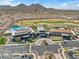 Aerial view of the recreational center, pool, and golf course with mountains in the background at 26336 W Tina Ln, Buckeye, AZ 85396