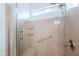 Modern walk-in shower featuring a built-in bench, grab bar, and neutral-colored tile, with a window providing natural light at 26336 W Tina Ln, Buckeye, AZ 85396