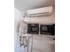 Utility room featuring storage shelves, a water heater, and a mini-split AC unit at 26336 W Tina Ln, Buckeye, AZ 85396
