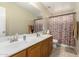 This bathroom has a double sink vanity, a large mirror, and a shower/tub combination with a patterned curtain at 31527 N Sundown N Dr, San Tan Valley, AZ 85143