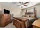 This bedroom includes a ceiling fan, a large dresser, and a traditional style bed and side table at 31527 N Sundown N Dr, San Tan Valley, AZ 85143