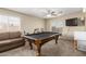 Recreational area with a pool table, sofa, TV, mini refrigerator, and natural light from the window at 31527 N Sundown N Dr, San Tan Valley, AZ 85143
