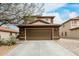 Tan two-story home featuring a two-car garage with a brown door and desert landscaping at 31527 N Sundown N Dr, San Tan Valley, AZ 85143