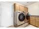 This laundry room features modern stainless steel washer and dryer, and a storage cabinet at 31527 N Sundown N Dr, San Tan Valley, AZ 85143