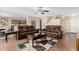 Open-concept living room features tile floors, ceiling fan, staircase, and two brown leather sofas at 31527 N Sundown N Dr, San Tan Valley, AZ 85143