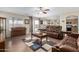 Open-concept living room features tile floors, leather sofas, sliding doors, piano, and adjacent kitchen at 31527 N Sundown N Dr, San Tan Valley, AZ 85143
