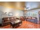 Inviting living room featuring hardwood floors, leather furniture, ceiling fan, and view into another room at 3224 W Ironwood Dr, Phoenix, AZ 85051