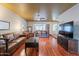 Inviting living room featuring hardwood floors, a ceiling fan, leather furniture, and plenty of natural light at 3224 W Ironwood Dr, Phoenix, AZ 85051
