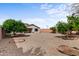 Expansive backyard with gravel landscaping, mature trees, and ample space for recreation and relaxation at 3253 N 138Th Ave, Avondale, AZ 85392