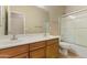Bathroom featuring dual sinks, warm wood cabinets, a framed mirror and a shower-tub combo at 3253 N 138Th Ave, Avondale, AZ 85392