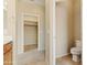 Bright bathroom featuring a wood cabinet, a toilet room and a walk-in closet at 3253 N 138Th Ave, Avondale, AZ 85392