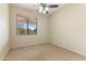 This bedroom features neutral carpeting, a ceiling fan and a window at 3253 N 138Th Ave, Avondale, AZ 85392