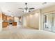 Open concept living room with a ceiling fan flows into kitchen and outdoor patio at 3253 N 138Th Ave, Avondale, AZ 85392
