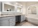 Bathroom featuring dual sinks, granite countertops, framed mirrors, bathtub and tile flooring at 3348 E Sequoia Dr, Phoenix, AZ 85050