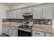 Kitchen featuring stainless appliances, granite counters, and gray cabinetry at 3348 E Sequoia Dr, Phoenix, AZ 85050