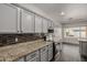 Well-lit kitchen with stainless appliances, granite counters, and gray cabinetry at 3348 E Sequoia Dr, Phoenix, AZ 85050