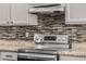 Close-up of the range in the modern kitchen with granite counters and tiled backsplash at 3348 E Sequoia Dr, Phoenix, AZ 85050