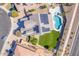 An aerial shot showcases a home with solar panels, a backyard oasis, and pristine artificial turf at 41581 W Somerset Dr, Maricopa, AZ 85138