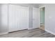 A clean bedroom features a double-door closet, gray walls, and stylish laminate flooring at 41581 W Somerset Dr, Maricopa, AZ 85138