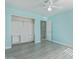 A spacious bedroom with blue walls, light laminate flooring and a walk-in closet at 41581 W Somerset Dr, Maricopa, AZ 85138