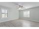Spacious bedroom with ceiling fan, neutral walls, and shuttered windows at 41581 W Somerset Dr, Maricopa, AZ 85138