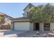 Exterior view of a two-story home featuring a two-car garage, neat landscaping with decorative rock, and an ADT security sign at 41581 W Somerset Dr, Maricopa, AZ 85138
