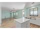 Open floor plan featuring a kitchen island and view to the living room and backyard pool at 41581 W Somerset Dr, Maricopa, AZ 85138