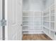 Walk-in pantry with a door and adjustable white shelving for ample storage and organization at 41581 W Somerset Dr, Maricopa, AZ 85138