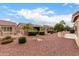 Expansive backyard featuring landscaping and a covered patio in a xeriscaped yard at 42911 W Magic Moment Dr, Maricopa, AZ 85138