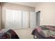 Spacious bedroom featuring a closet with sliding doors and neutral walls and carpet at 42911 W Magic Moment Dr, Maricopa, AZ 85138