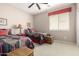 Inviting bedroom with two twin beds, ceiling fan, neutral walls, and natural light from the window at 42911 W Magic Moment Dr, Maricopa, AZ 85138