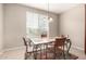Cozy dining area featuring natural light from the windows and a modern chandelier at 42911 W Magic Moment Dr, Maricopa, AZ 85138