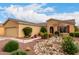 A beautiful home with desert landscaping, including rocks and plants, with a walkway leading to the front door at 42911 W Magic Moment Dr, Maricopa, AZ 85138