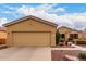 Charming home featuring a well-maintained front yard, tan stucco, a two-car garage, and a beautiful landscape at 42911 W Magic Moment Dr, Maricopa, AZ 85138