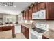 Bright kitchen featuring appliances, wooden cabinets, and an open layout at 42911 W Magic Moment Dr, Maricopa, AZ 85138