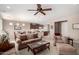 Comfortable living room with open concept to the kitchen featuring neutral colors, ceiling fan, and cozy furniture at 42911 W Magic Moment Dr, Maricopa, AZ 85138