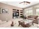 Cozy living room with built-in shelving, a large window, and plush seating, creating a relaxing and inviting atmosphere at 42911 W Magic Moment Dr, Maricopa, AZ 85138