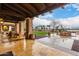 Beautiful outdoor patio area with elegant tiling and shaded seating, perfect for enjoying the community lake view at 42911 W Magic Moment Dr, Maricopa, AZ 85138