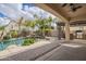 Luxurious backyard featuring a pool with rock waterfall and a covered outdoor kitchen area at 4576 E Waterman St, Gilbert, AZ 85297